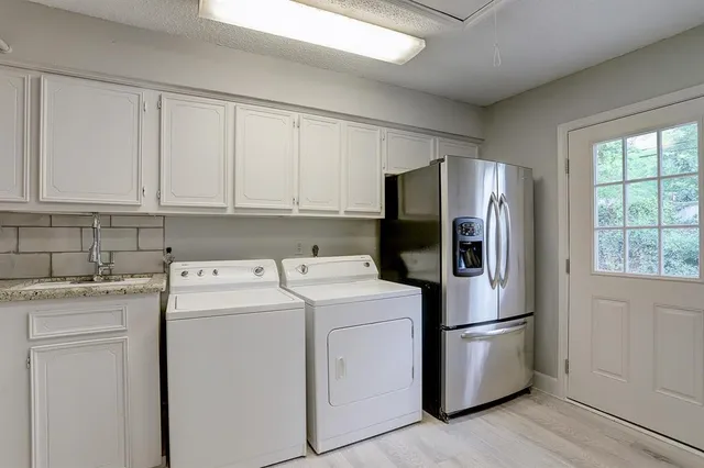 a view of a kitchen with refrigerator and cabinets