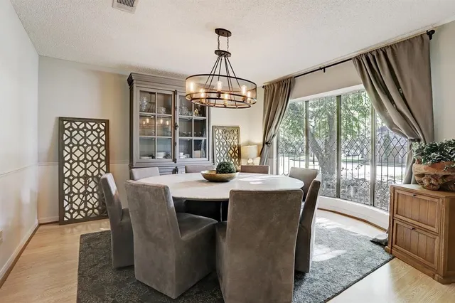 a dining room with furniture a chandelier and wooden floor