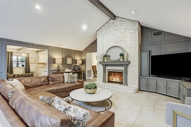 a living room with furniture a fireplace and a flat screen tv