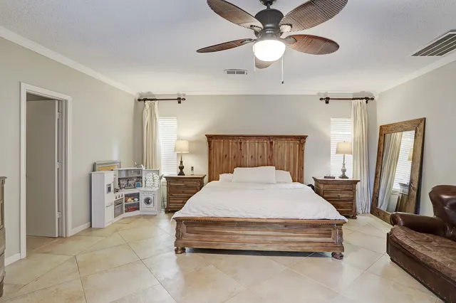 a spacious bedroom with a bed a couch and a chandelier