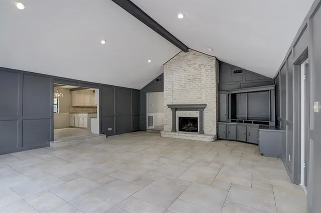a view of an empty room with a fireplace and a window