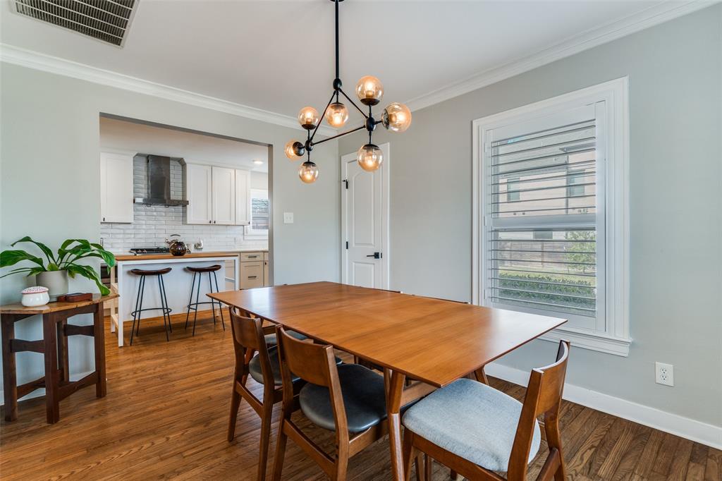 4245 Concho Street Dallas, TX 75206 - Photo 10 of 30 Dining room featuring dark wood finished floors, a chandelier, and ornamental molding