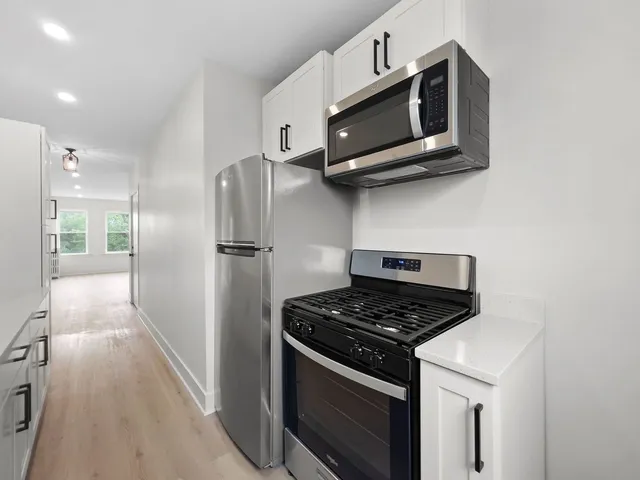 a kitchen with stainless steel appliances granite countertop a stove and a microwave