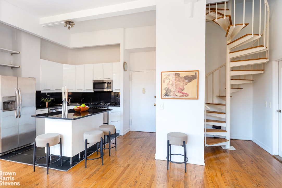 2 Cornelia Street, Unit 404 Manhattan, NY 10014 - Photo 5 of 13 a living room with furniture and a wooden floor