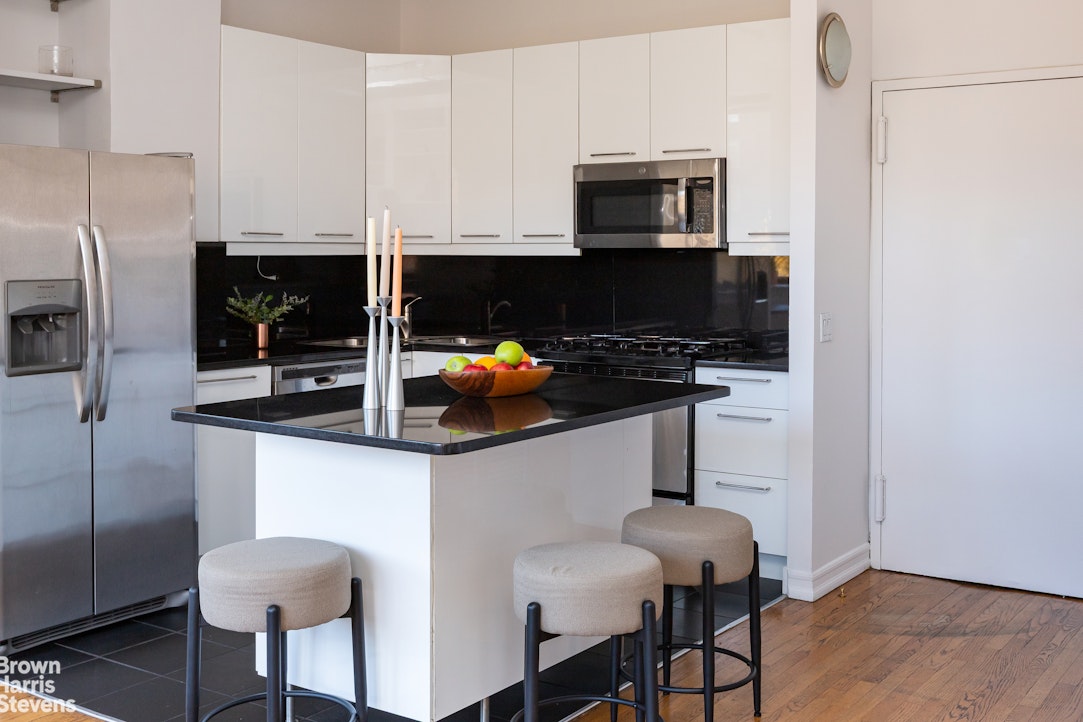 2 Cornelia Street, Unit 404 Manhattan, NY 10014 - Photo 6 of 13 a kitchen with stainless steel appliances a stove a refrigerator and a microwave