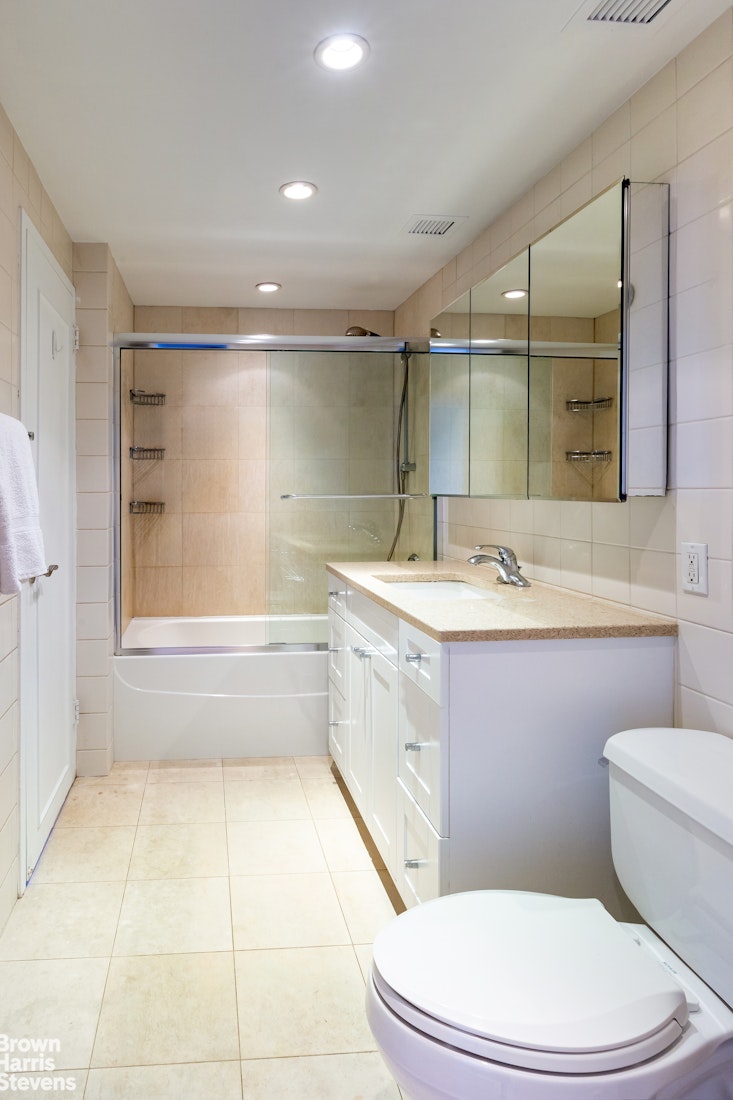 2 Cornelia Street, Unit 404 Manhattan, NY 10014 - Photo 9 of 13 a bathroom with a sink a toilet a mirror and vanity