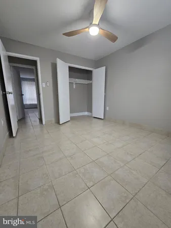 an empty room with a ceiling fan and carpet