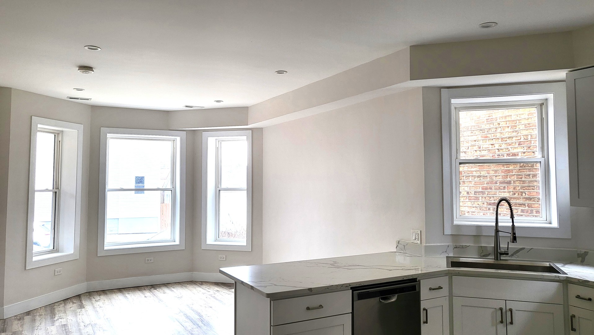2904 West Nelson Street, Unit 2 Chicago, IL 60618 - Photo 3 of 12 a kitchen with granite countertop a sink and a window
