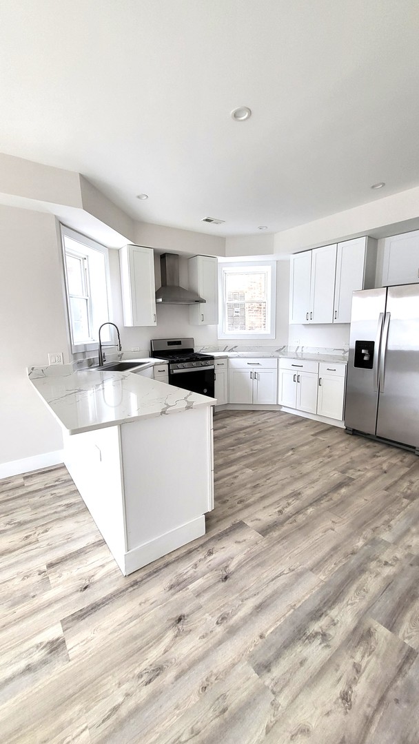 2904 West Nelson Street, Unit 2 Chicago, IL 60618 - Photo 5 of 12 a kitchen with granite countertop a stove a sink and a granite counter tops