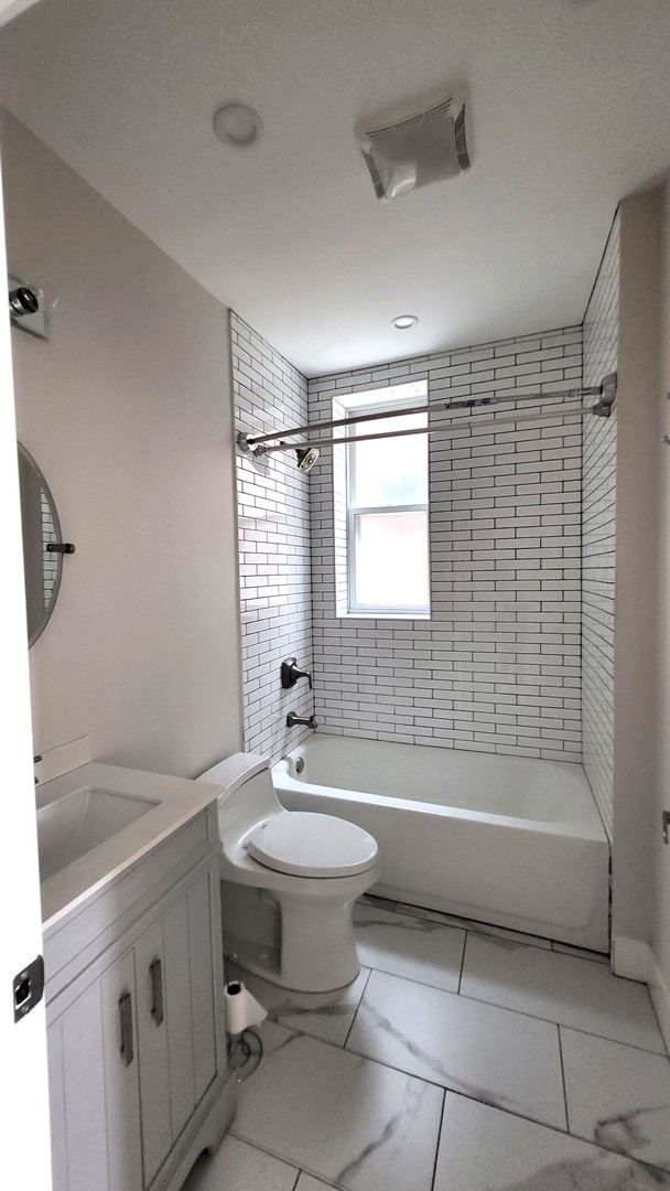 2904 West Nelson Street, Unit 2 Chicago, IL 60618 - Photo 9 of 12 a bathroom with a sink mirror toilet and bathtub