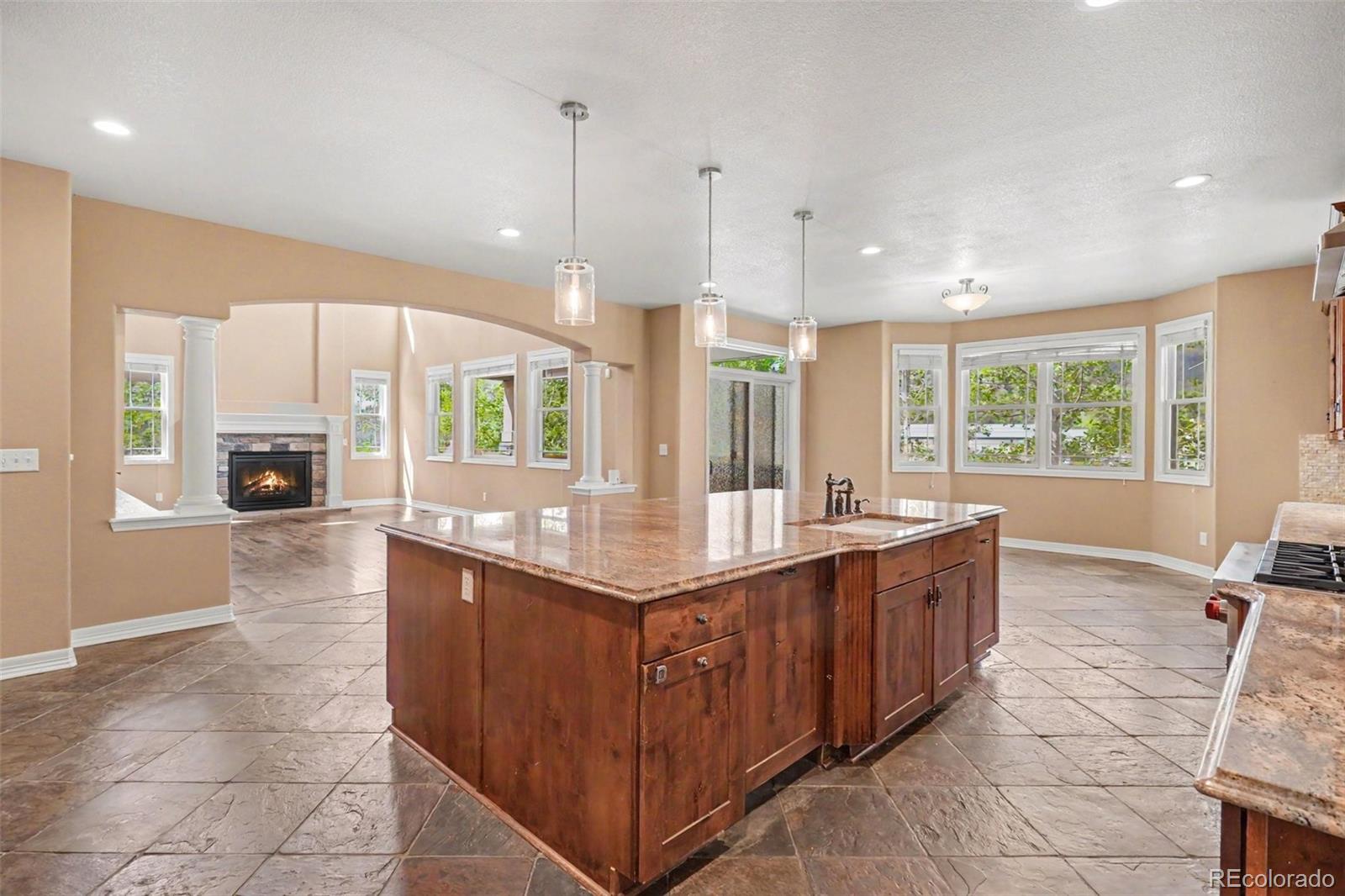 791 Elk Rest Road Evergreen, CO 80439 - Photo 9 of 46 a large kitchen with kitchen island granite countertop a large counter top and wooden floors