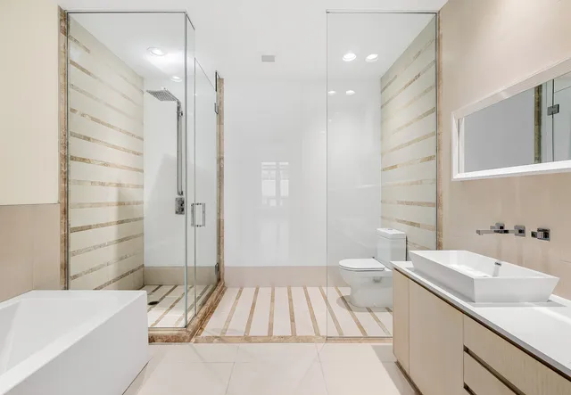 a bathroom with a double vanity sink a toilet and shower