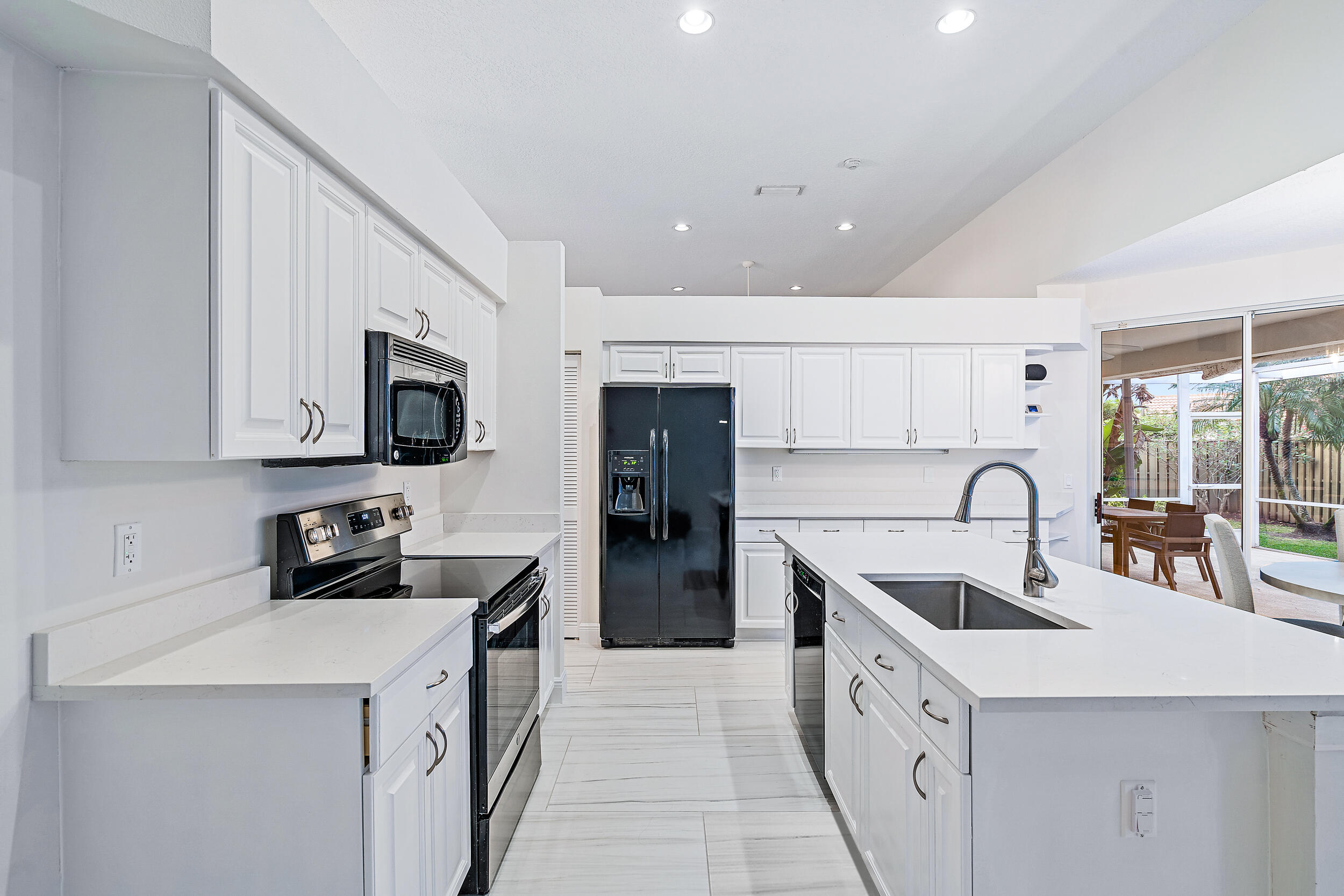 207 Eagleton Estates Boulevard Palm Beach Gardens, FL 33418 - Photo 15 of 34 a kitchen with stainless steel appliances granite countertop a sink a stove and refrigerator