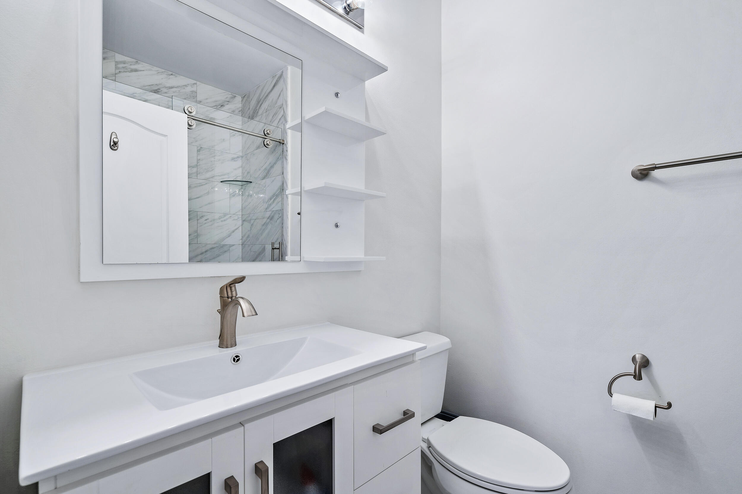 207 Eagleton Estates Boulevard Palm Beach Gardens, FL 33418 - Photo 19 of 34 a bathroom with a sink a toilet and a mirror