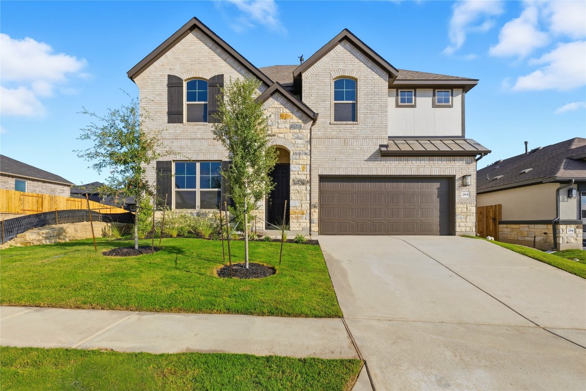 264 Rubber Tree Way Buda, TX 78610 - Photo 1 of 1 French country style house featuring brick siding, a standing seam roof, and stone siding