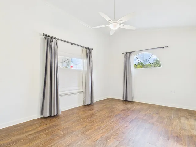 an empty room with a window and a ceiling fan