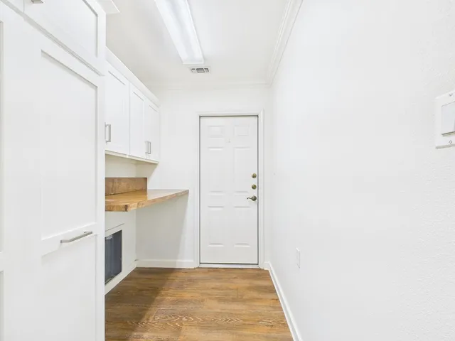 a view of an empty room with cabinet and entryway