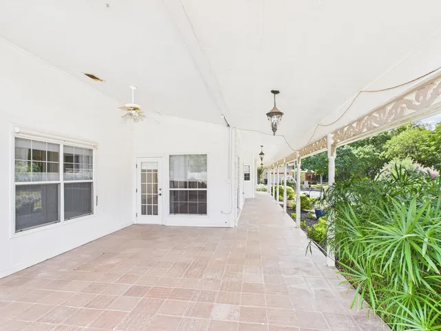 a view of a house with a yard and potted plants