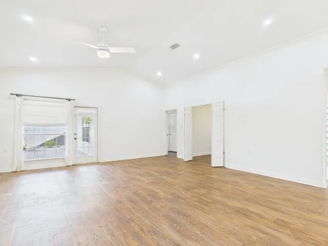 an empty room with wooden floor and door