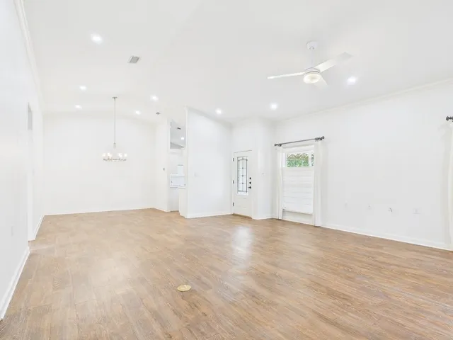 a view of an empty room with wooden floor