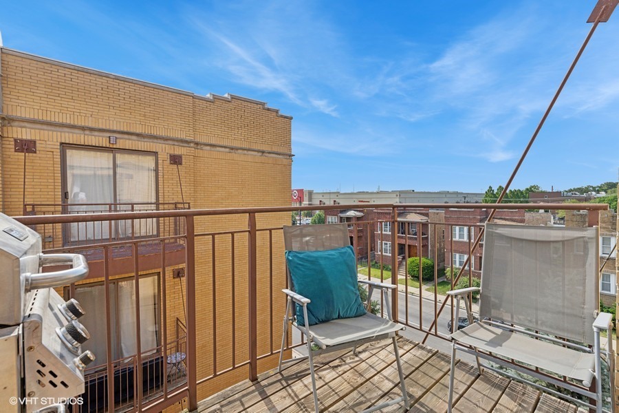 3012 West Addison Street, Unit 4S Chicago, IL 60618 - Photo 15 of 16 a view of a balcony with wooden fence and floor to ceiling window