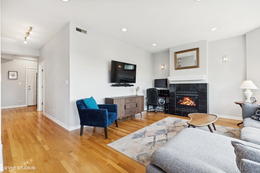 3012 West Addison Street, Unit 4S Chicago, IL 60618 - Photo 4 of 16 a living room with furniture a flat screen tv and a fireplace