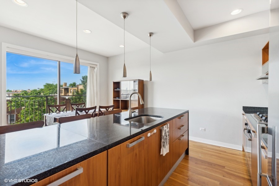 3012 West Addison Street, Unit 4S Chicago, IL 60618 - Photo 6 of 16 a kitchen with stainless steel appliances granite countertop a sink a counter space and a window