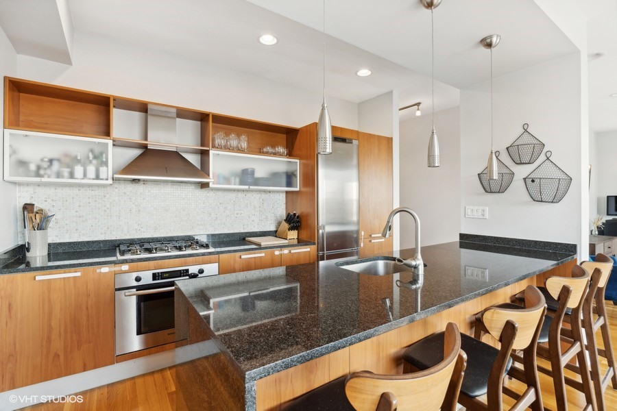 3012 West Addison Street, Unit 4S Chicago, IL 60618 - Photo 7 of 16 a kitchen with stainless steel appliances granite countertop a stove a sink and a microwave