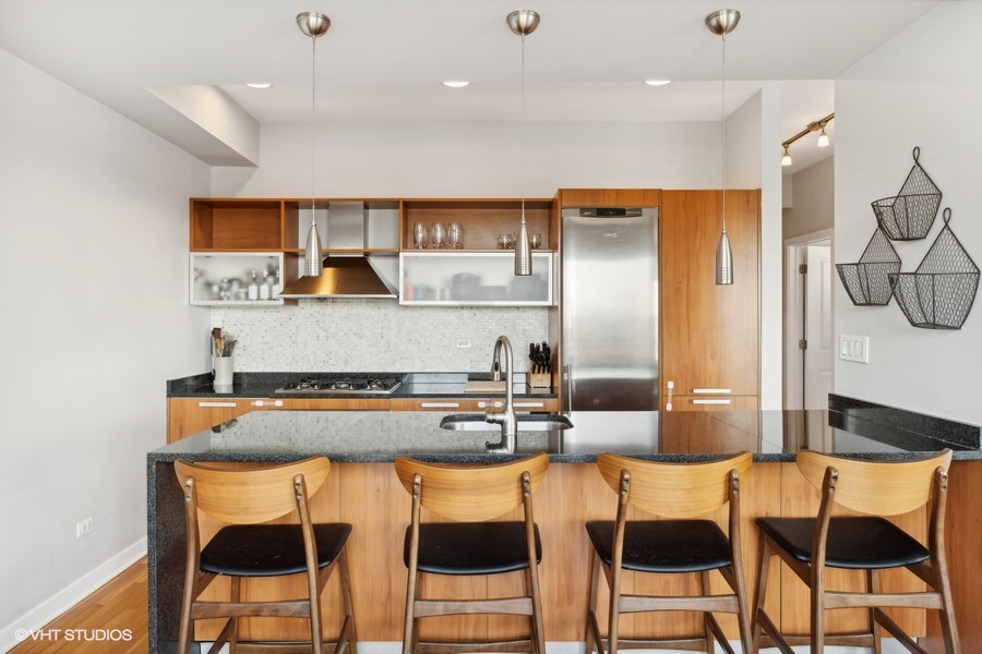 3012 West Addison Street, Unit 4S Chicago, IL 60618 - Photo 8 of 16 a kitchen with stainless steel appliances granite countertop a table and chairs in it