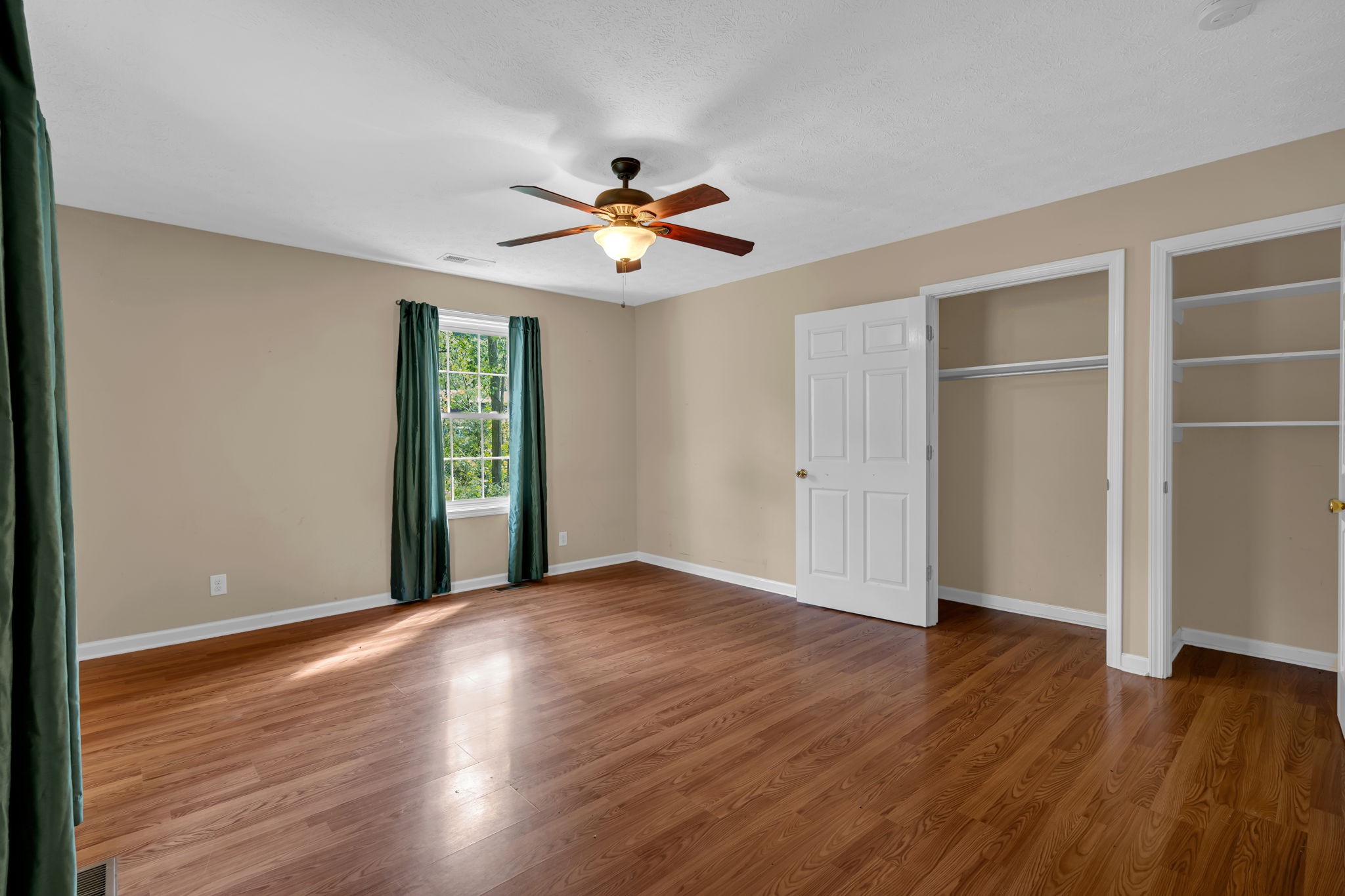 1297 Dry Creek Road Ashland City, TN 37015 - Photo 20 of 27 an empty room with wooden floor chandelier fan and windows