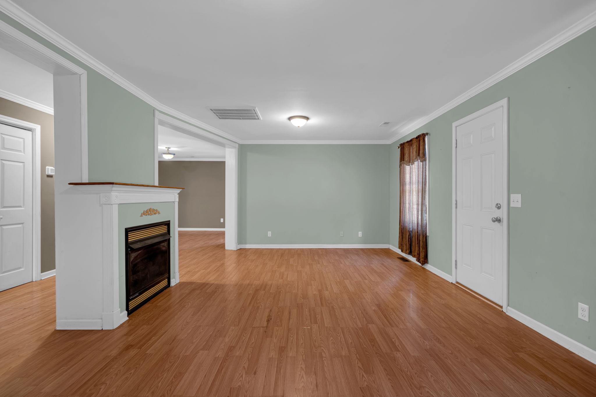 1297 Dry Creek Road Ashland City, TN 37015 - Photo 5 of 27 a view of an empty room with wooden floor fireplace and a window
