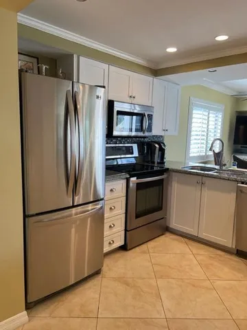 a kitchen with granite countertop a refrigerator and a sink