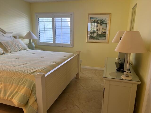 1605 Highway 1, Unit A301 Jupiter, FL 33477 - Photo 21 of 35 a bedroom with a bed and a lamp on table