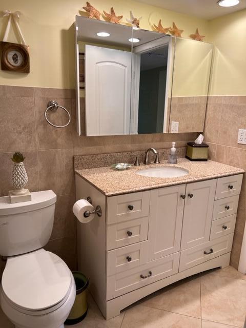 1605 Highway 1, Unit A301 Jupiter, FL 33477 - Photo 23 of 35 a bathroom with a granite countertop toilet sink and mirror