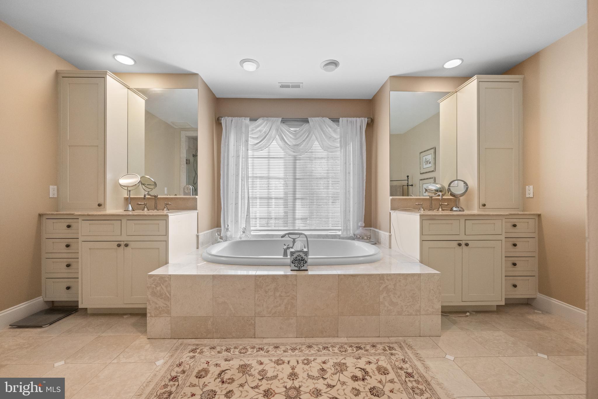 825 Hagys Ford Road Penn Valley, PA 19072 - Photo 33 of 45 a spacious bathroom with a double vanity sink large mirror and a bathtub