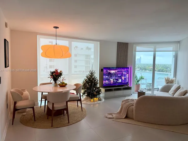 a living room with furniture a chandelier and a large window
