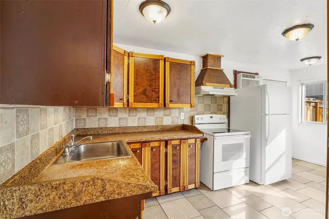 a kitchen with stainless steel appliances granite countertop a sink refrigerator and cabinets