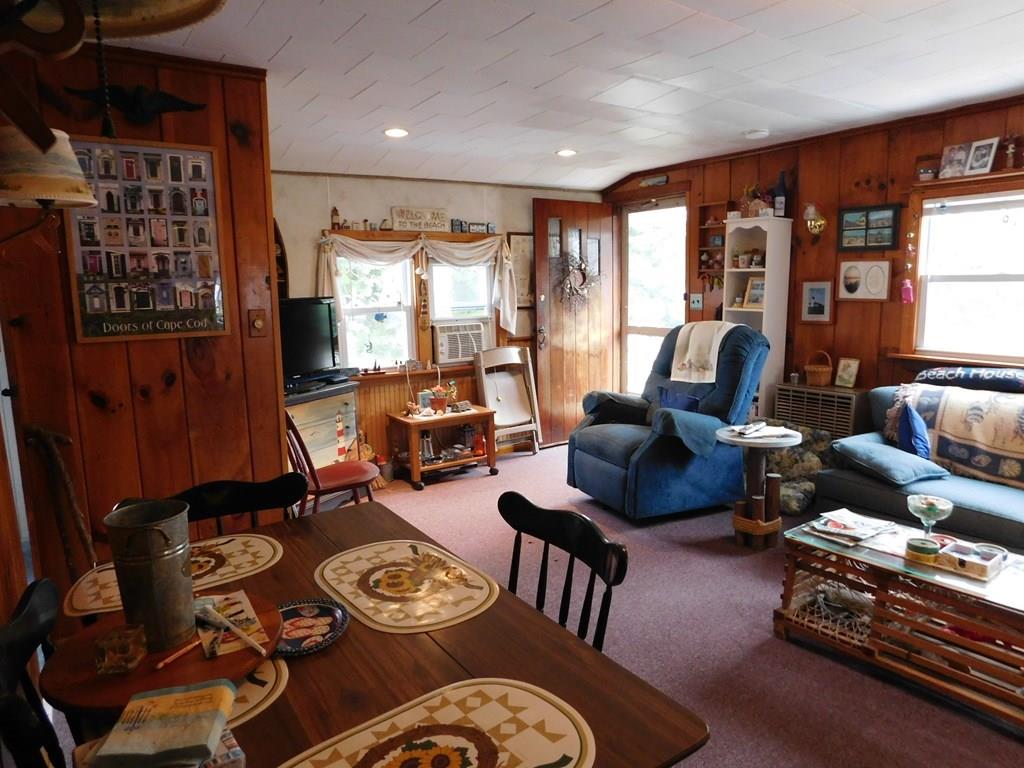218 Old Wharf Road, Unit 218 Dennis, MA 02639 - Photo 21 of 32 a living room with furniture and a floor to ceiling window