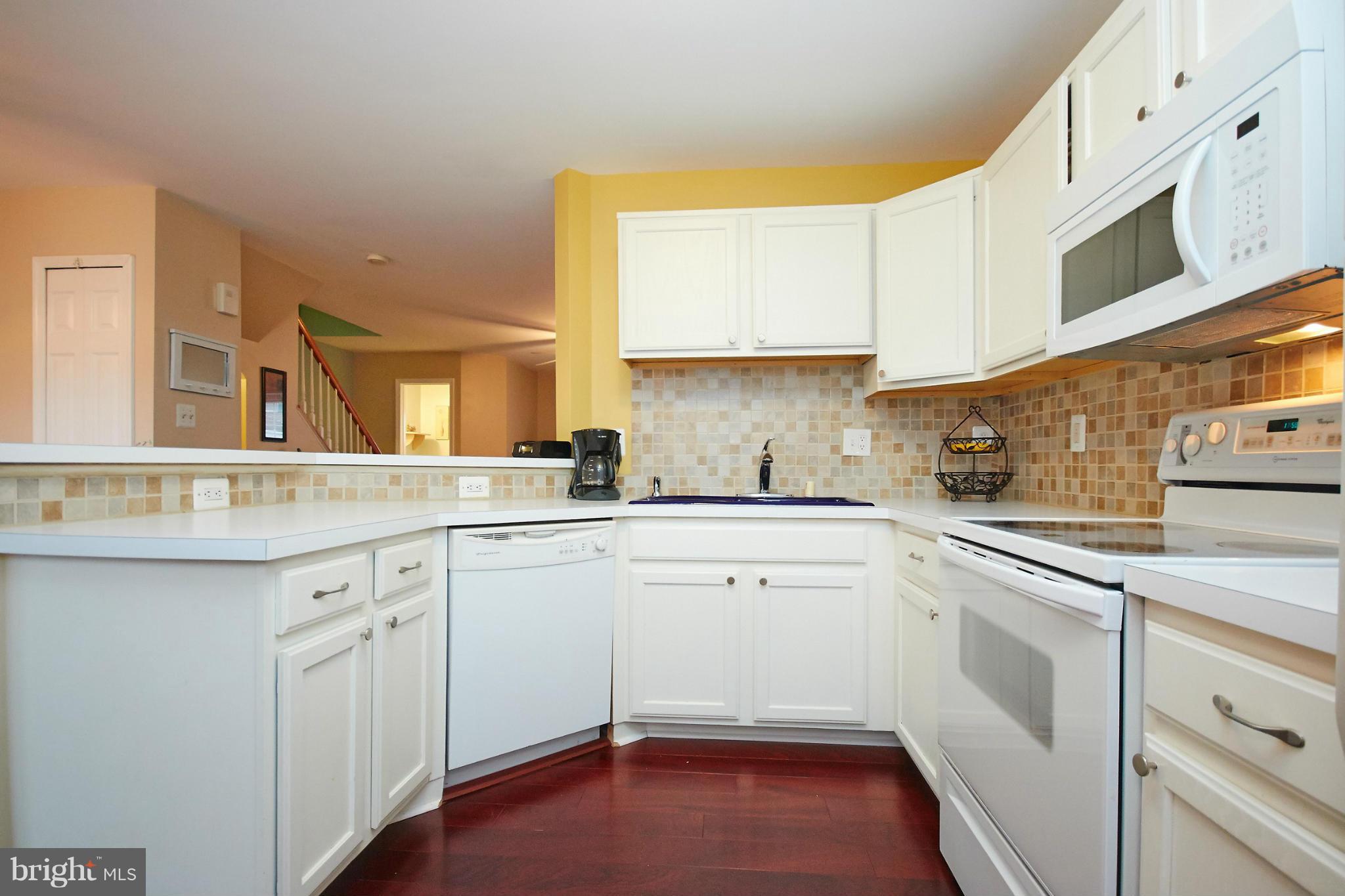 8461 Tackhouse Loop Gainesville, VA 20155 - Photo 11 of 29 a kitchen with white cabinets appliances a sink and a window