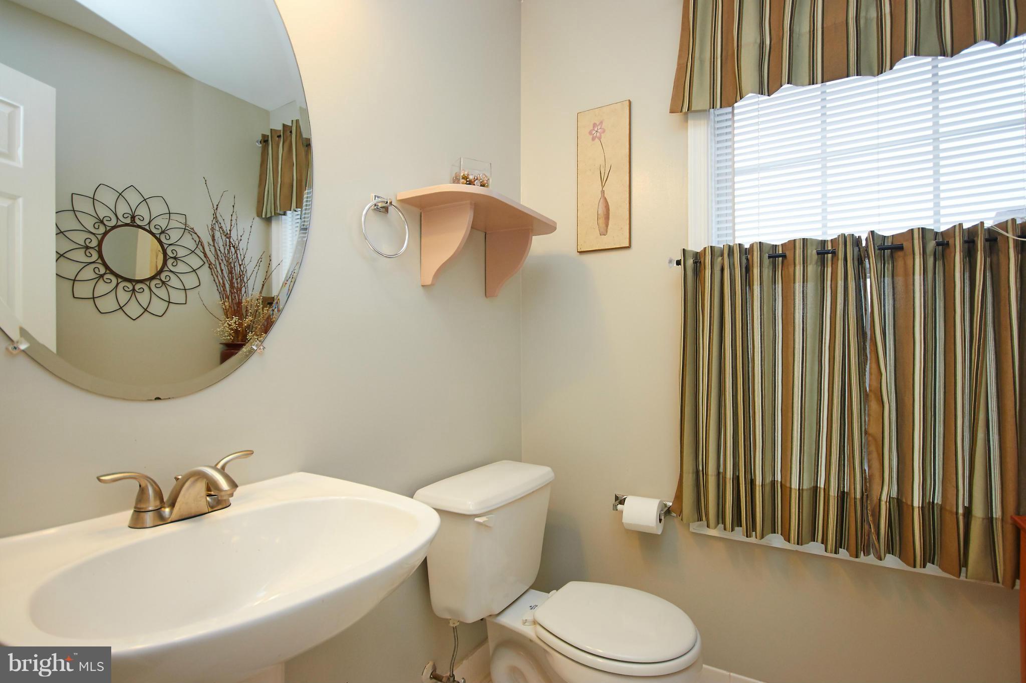 8461 Tackhouse Loop Gainesville, VA 20155 - Photo 13 of 29 a bathroom with a toilet a sink and mirror