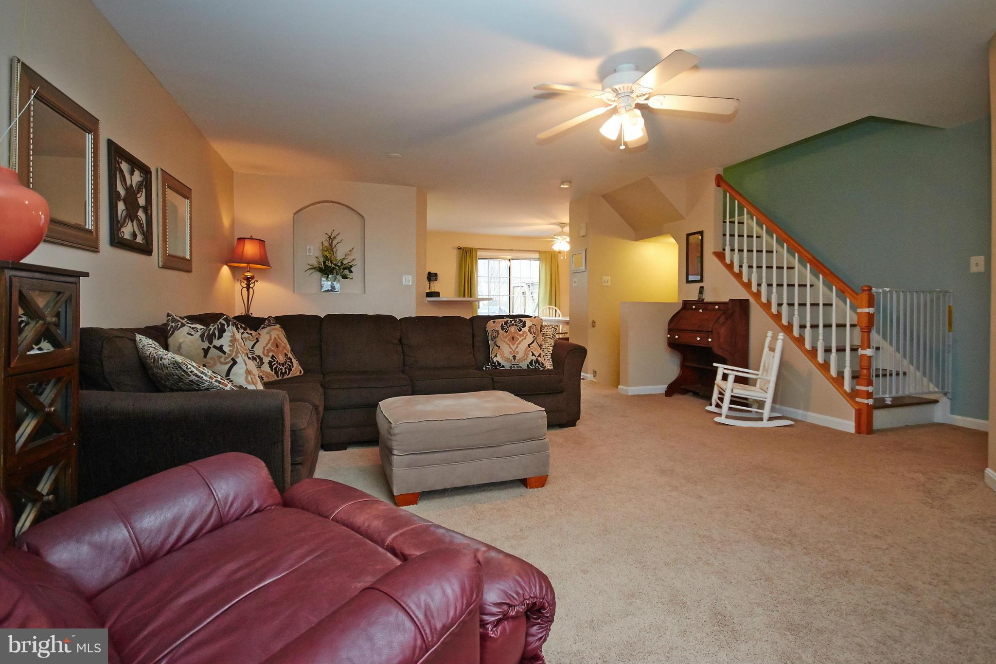 8461 Tackhouse Loop Gainesville, VA 20155 - Photo 5 of 29 a living room with furniture and a ceiling fan
