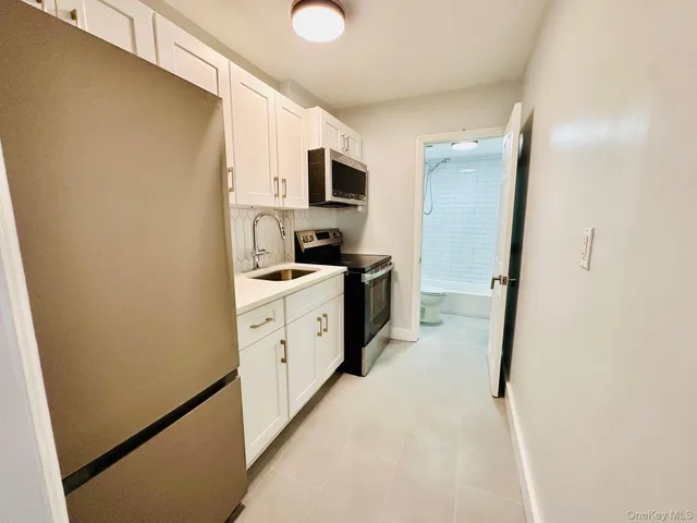 a kitchen with cabinets stainless steel appliances a sink and wooden floor