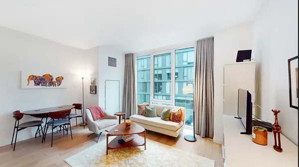 a living room with furniture a window and a flat screen tv