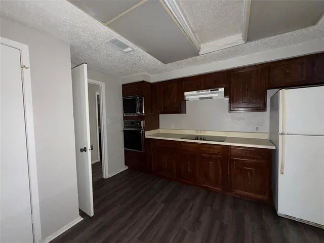 a kitchen with stainless steel appliances a refrigerator and wooden floor