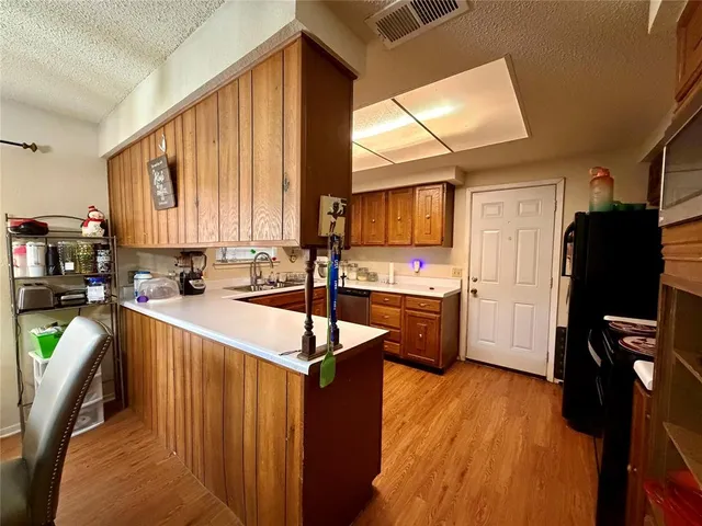a kitchen with stainless steel appliances a refrigerator sink and wooden cabinets