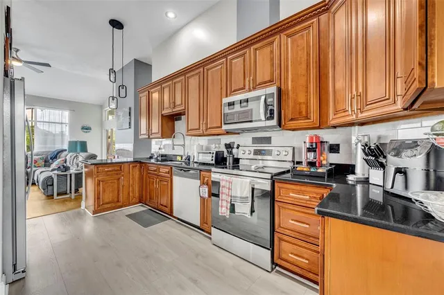 a kitchen with stainless steel appliances granite countertop a stove a sink and a microwave