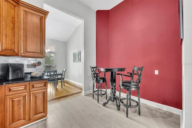 a kitchen with granite countertop a table chairs stove a sink and dishwasher