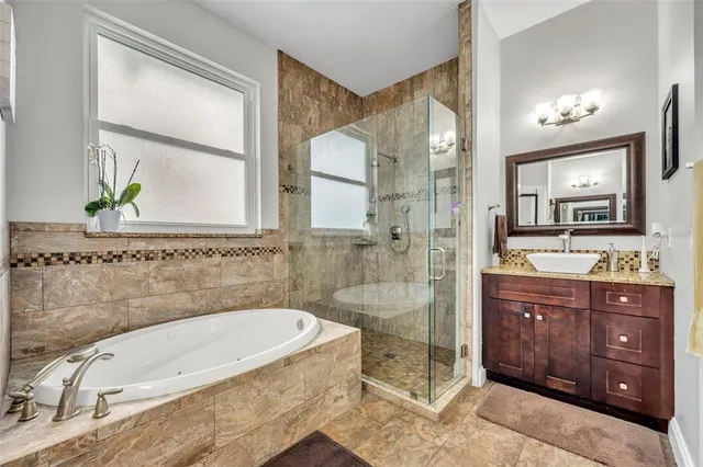 a bathroom with a tub a sink and glass door