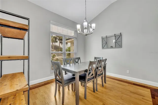 a view of a dining room with furniture a chandelier and wooden floor