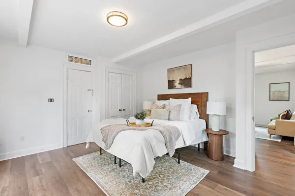 a bedroom with a bed and wooden floor